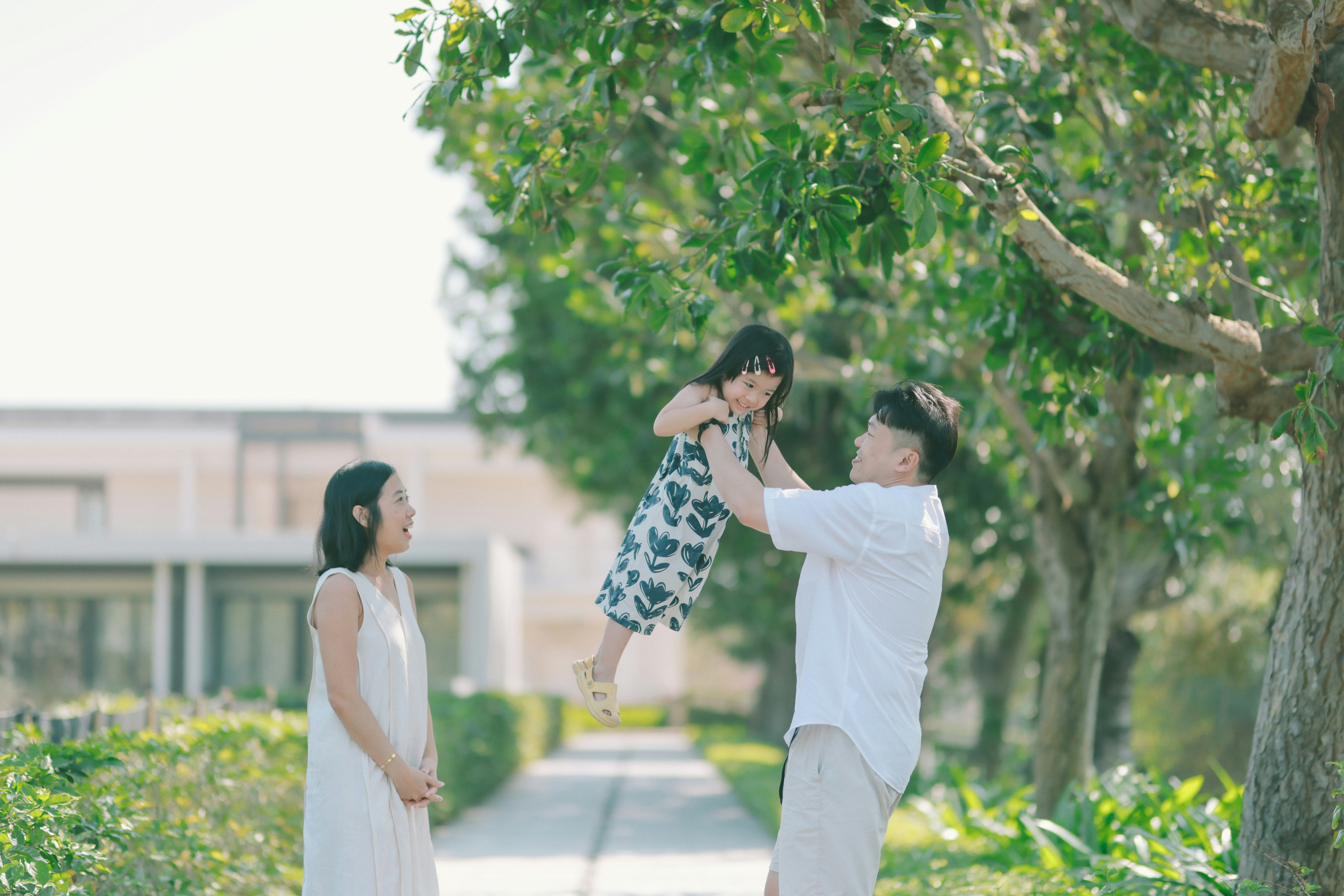 Father throws daughter in the air with family watching
