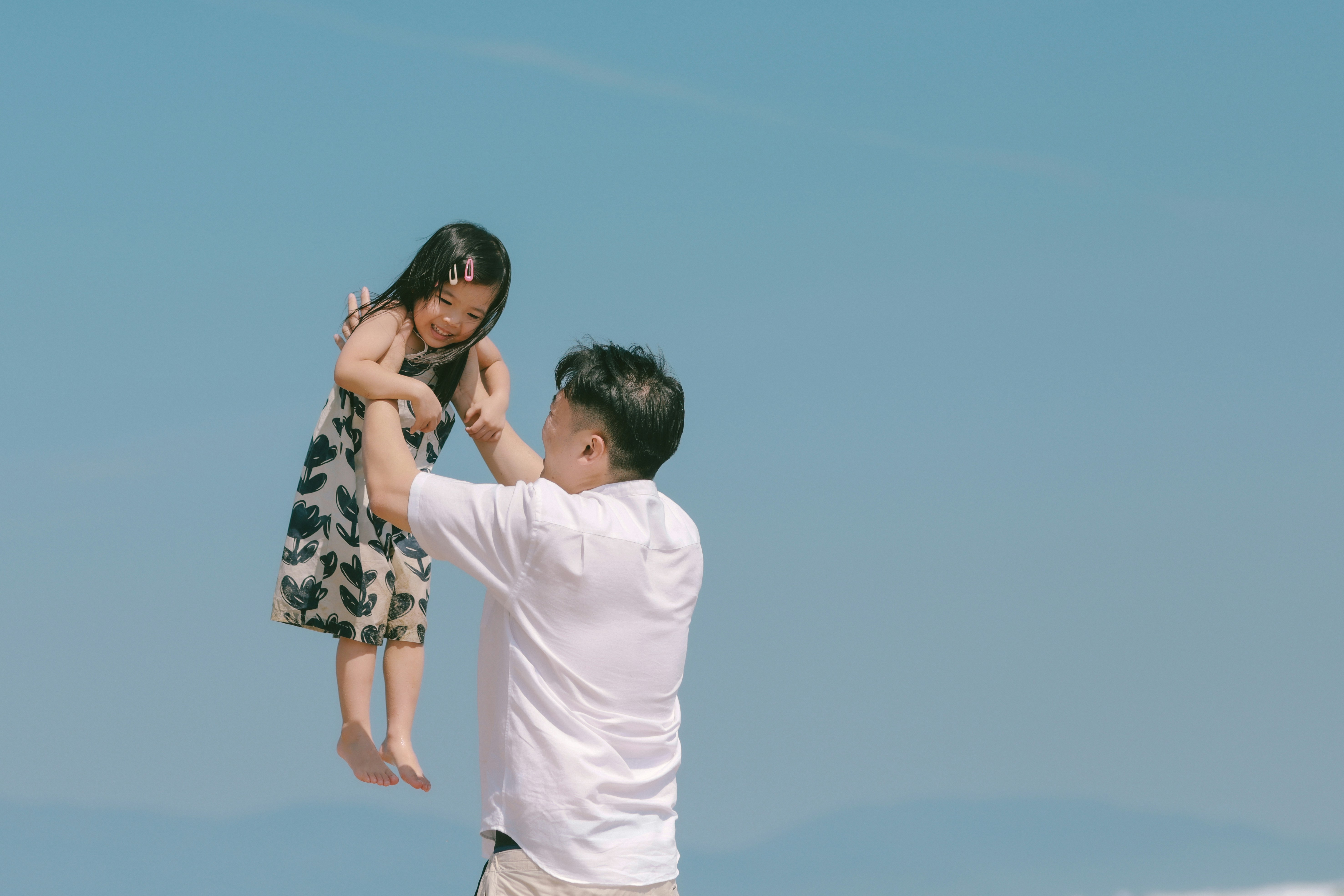 Father lifting his daughter high in the air