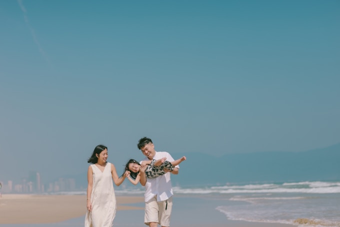 Family walking on a beach with clear blue sky