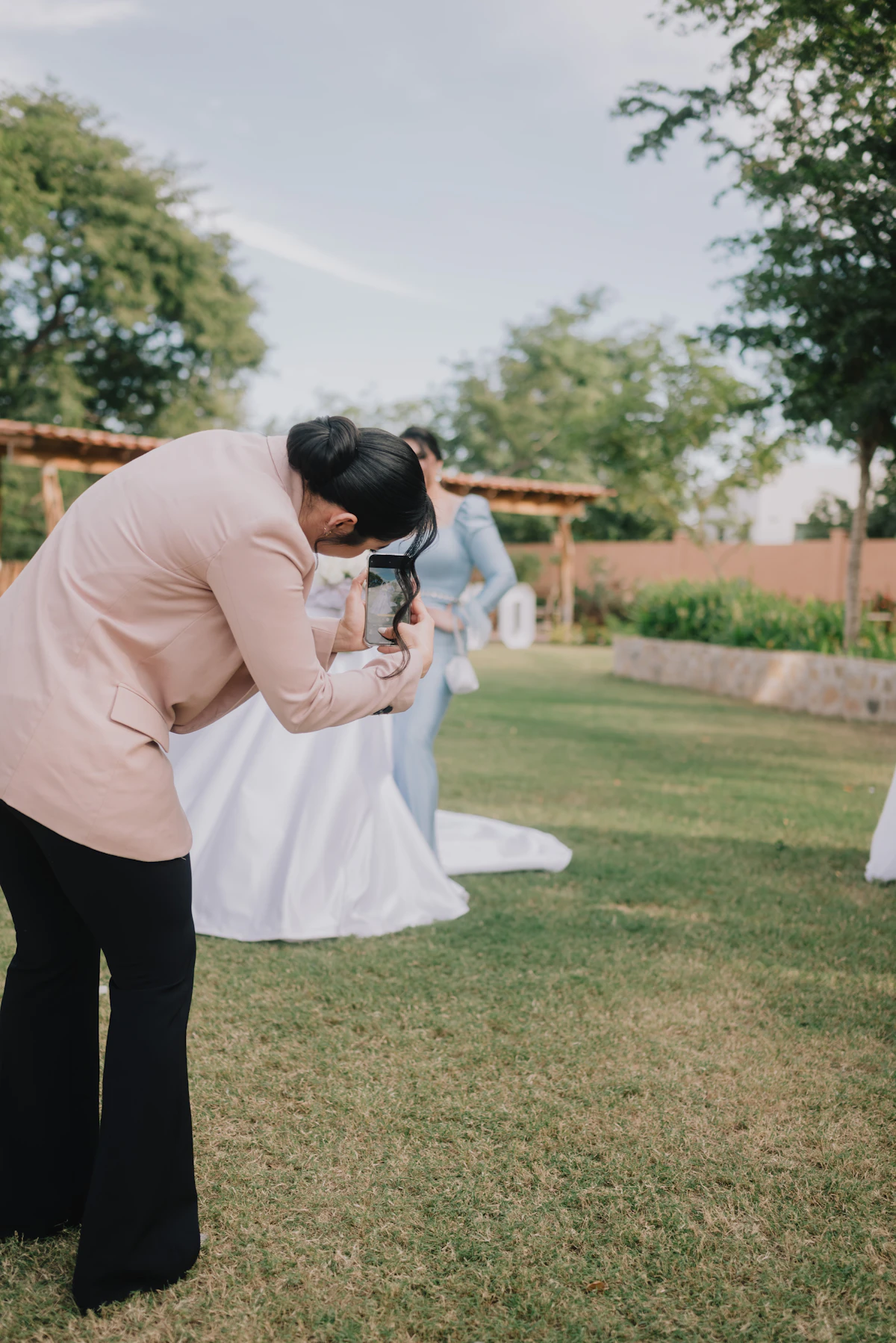 Professional photographer confidently working at a wedding, directing the bride