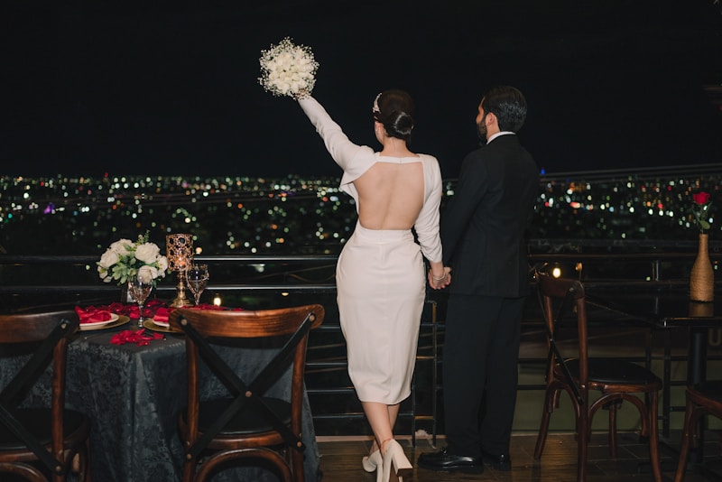 Pareja en balcón con vista a ciudad iluminada