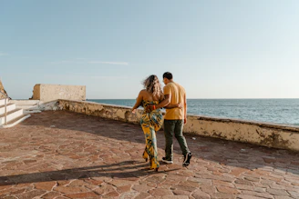 Couple walking along a coastal path by the sea.