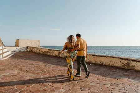 Couple walking along a coastal path by the sea.