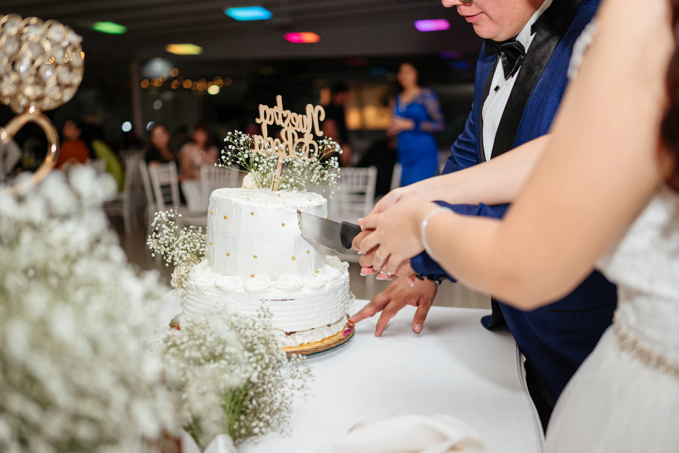 How to find top-rated wedding cake bakers — A baker adding delicate frosting details to a three-tier wedding cake.