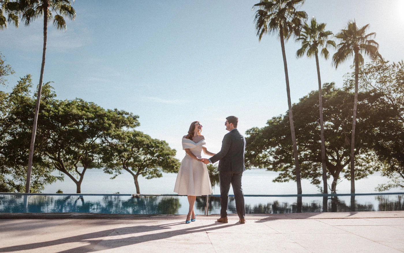 Bride and groom together among tall tropical palm trees