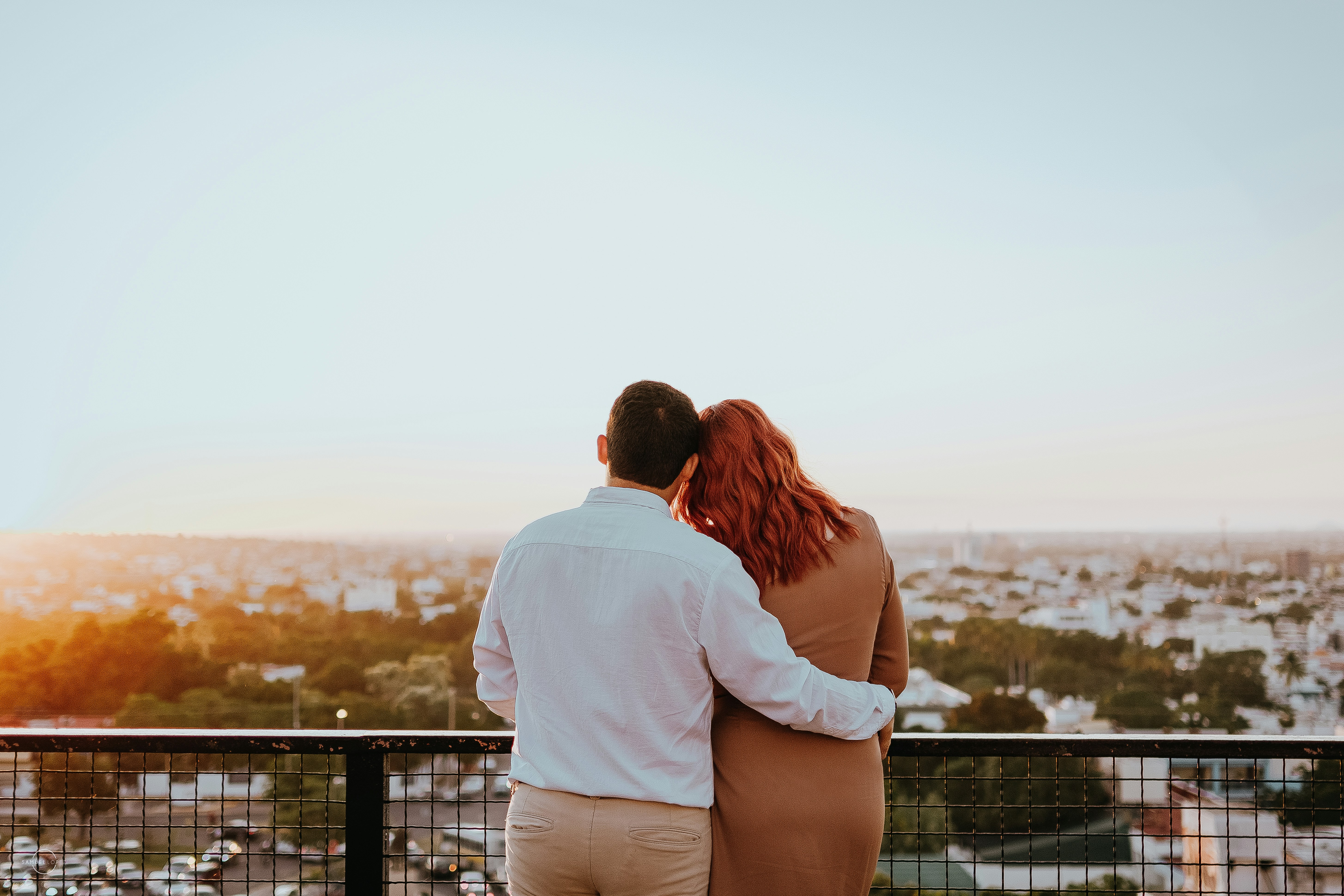 Couple embracing and watching city skyline at sunset
