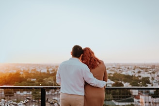 Couple embracing and watching city skyline at sunset