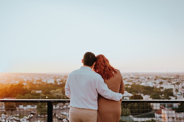 Couple embracing and watching city skyline at sunset