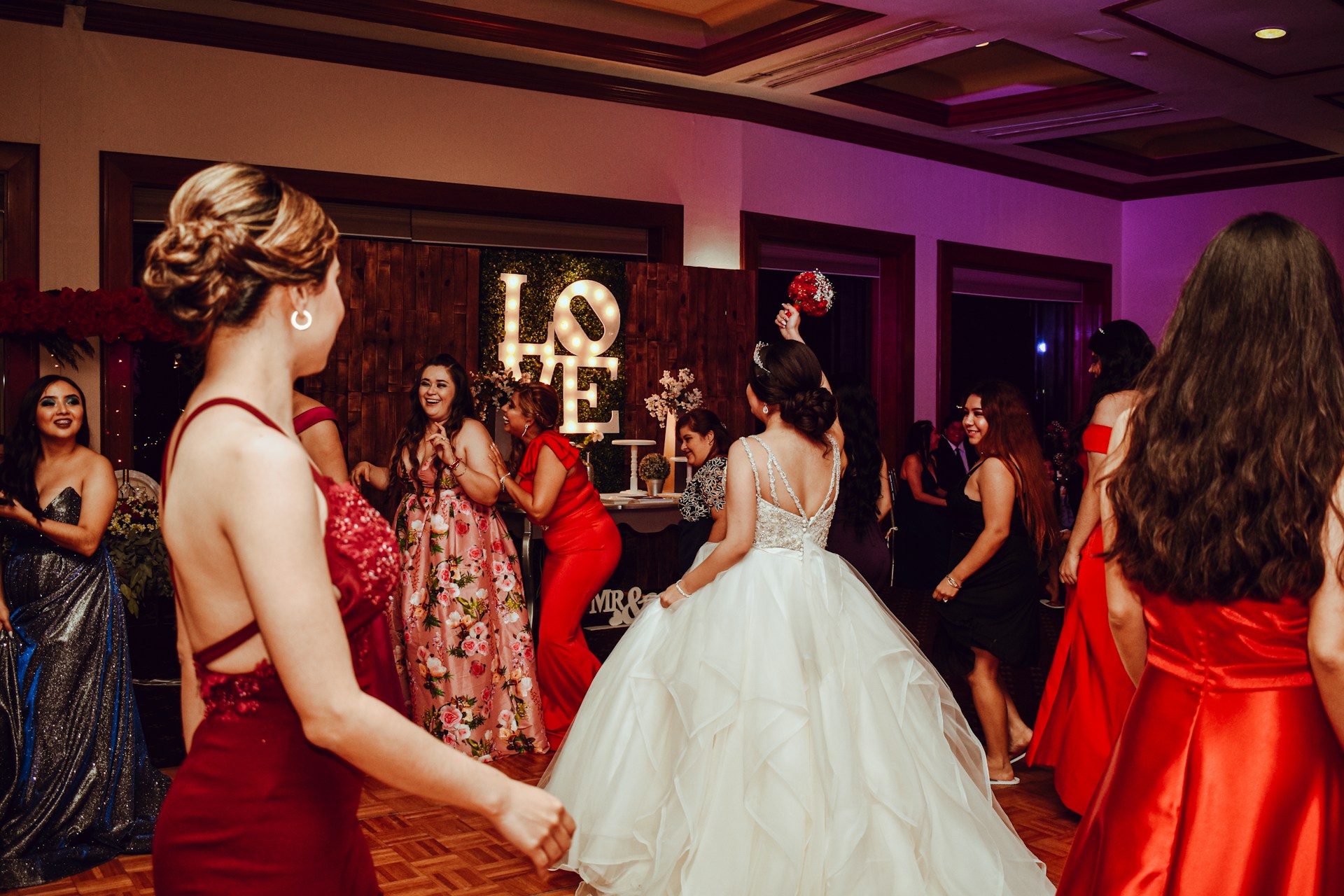 People dancing at a formal event with a love sign.