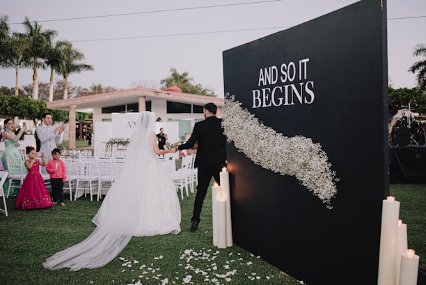 Couple walks through a floral display at an event.