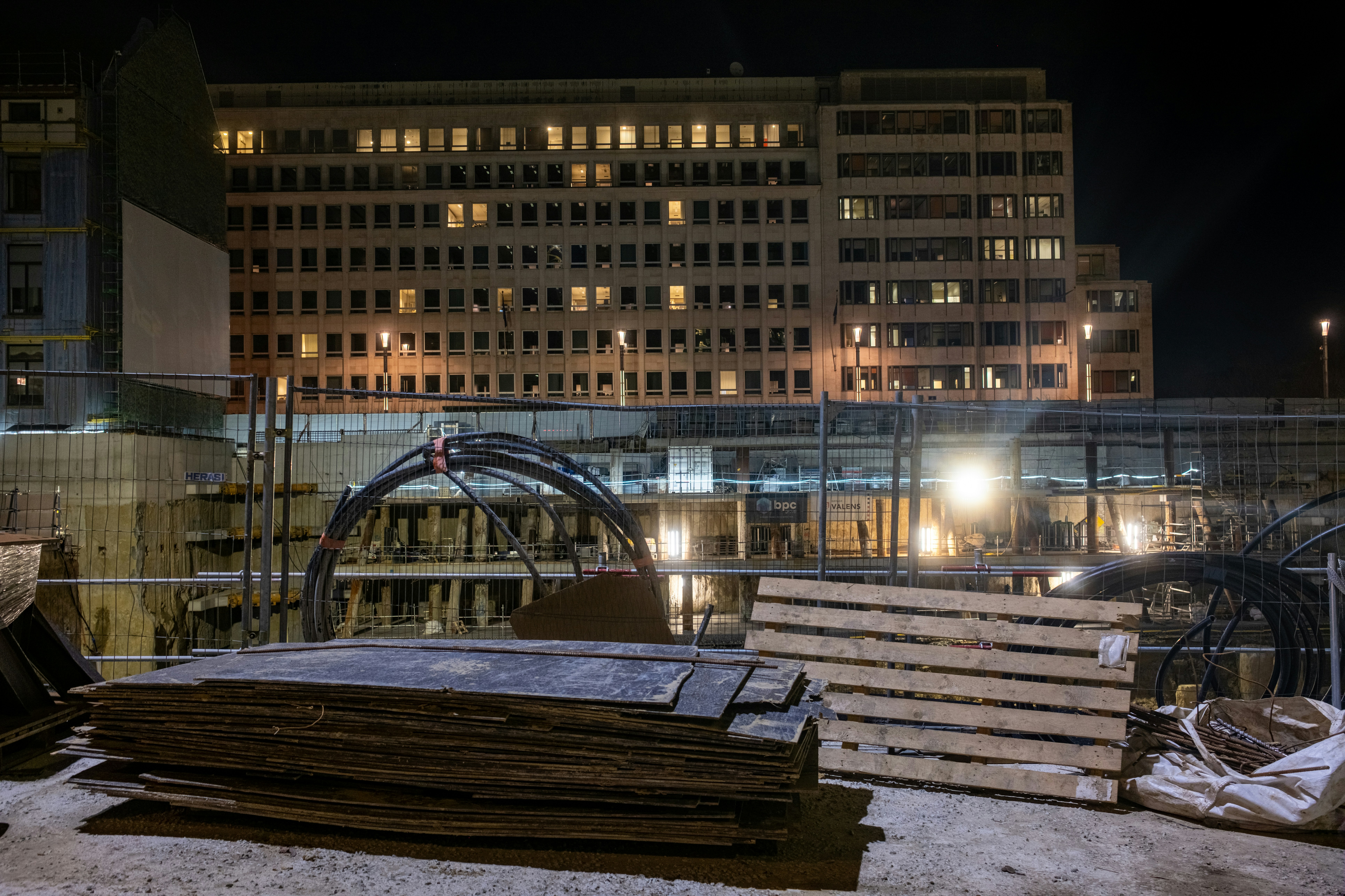 Construction site with building in background at night
