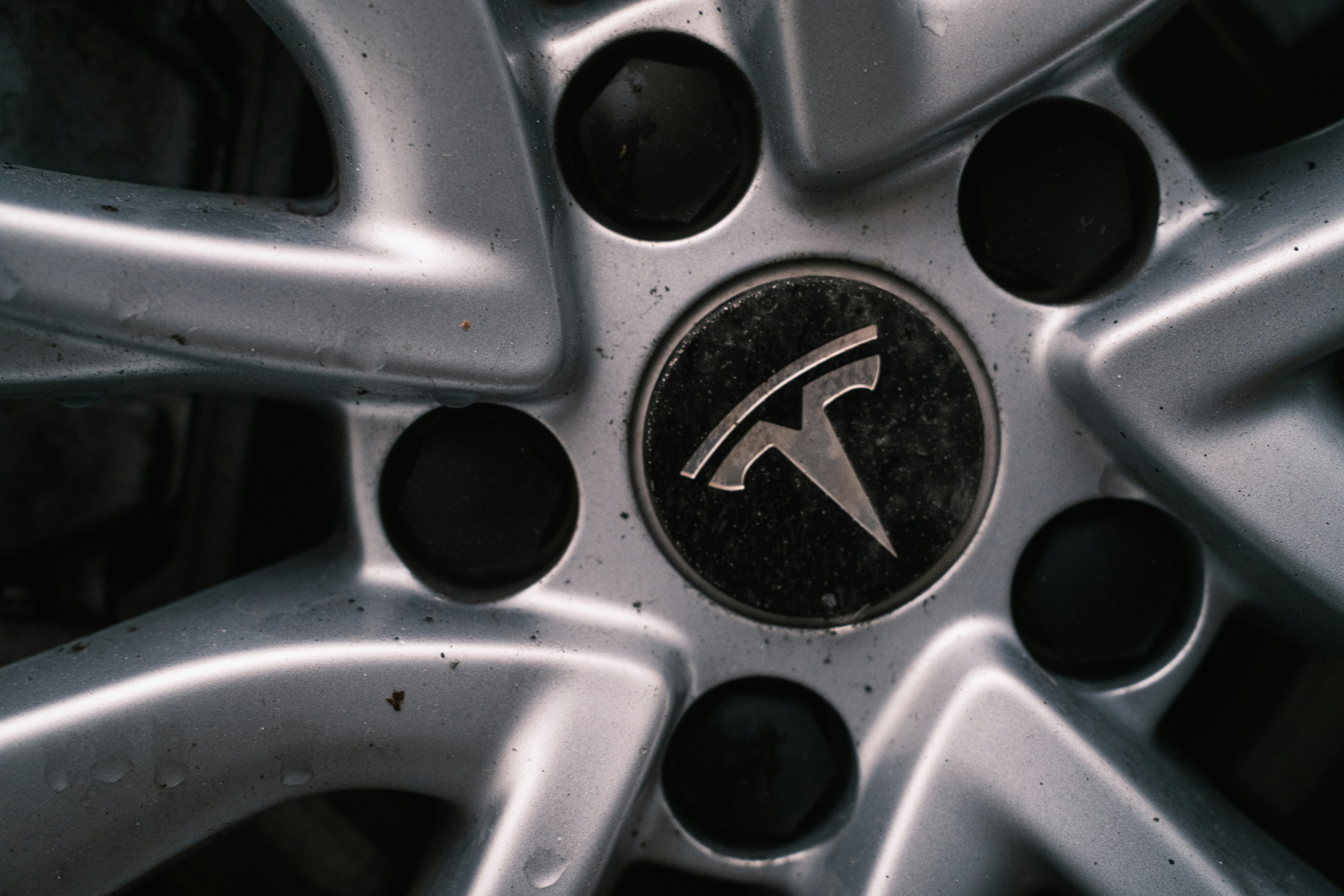 Close-up of a tesla car wheel with logo.
