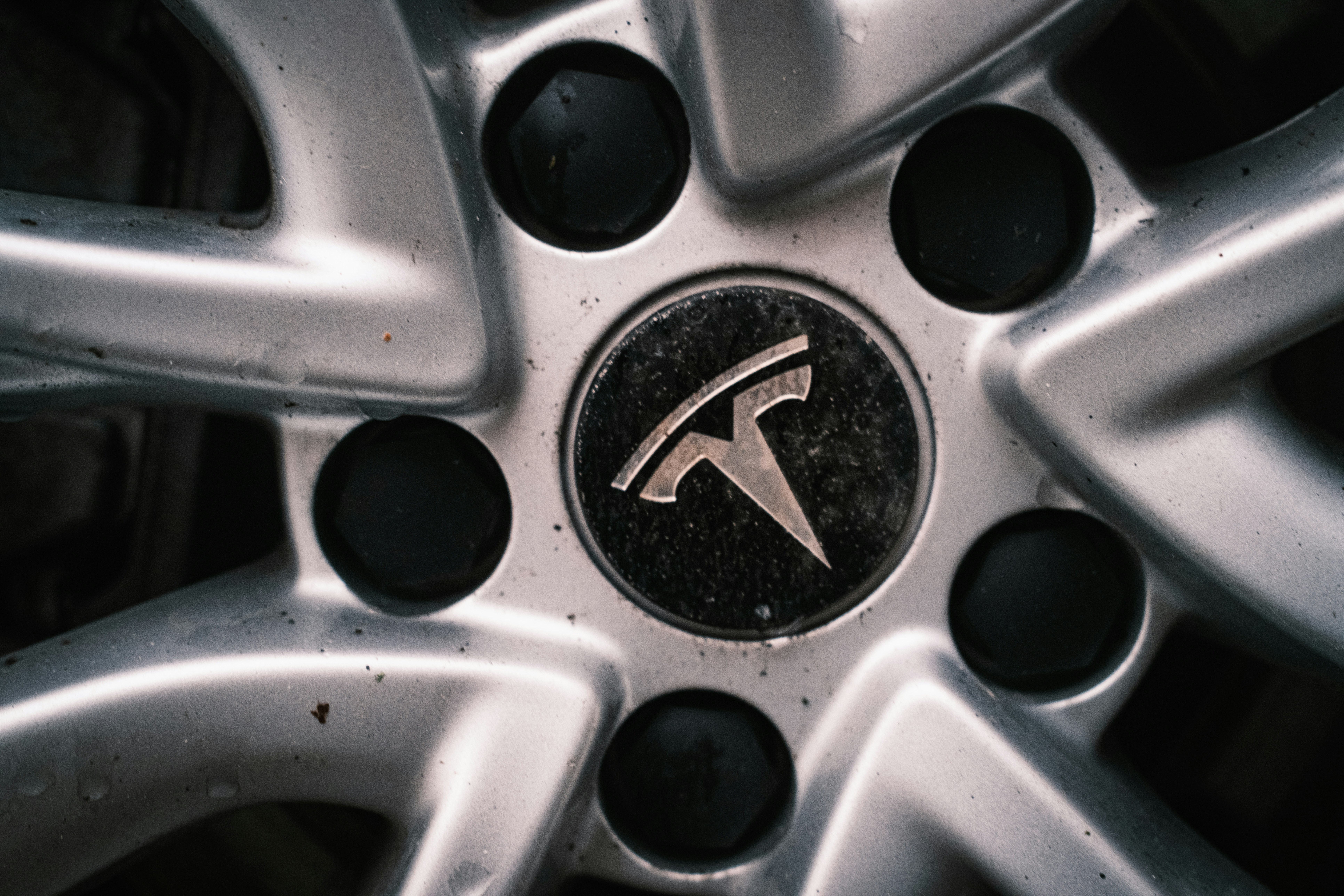 Close-up of a tesla car wheel with logo.