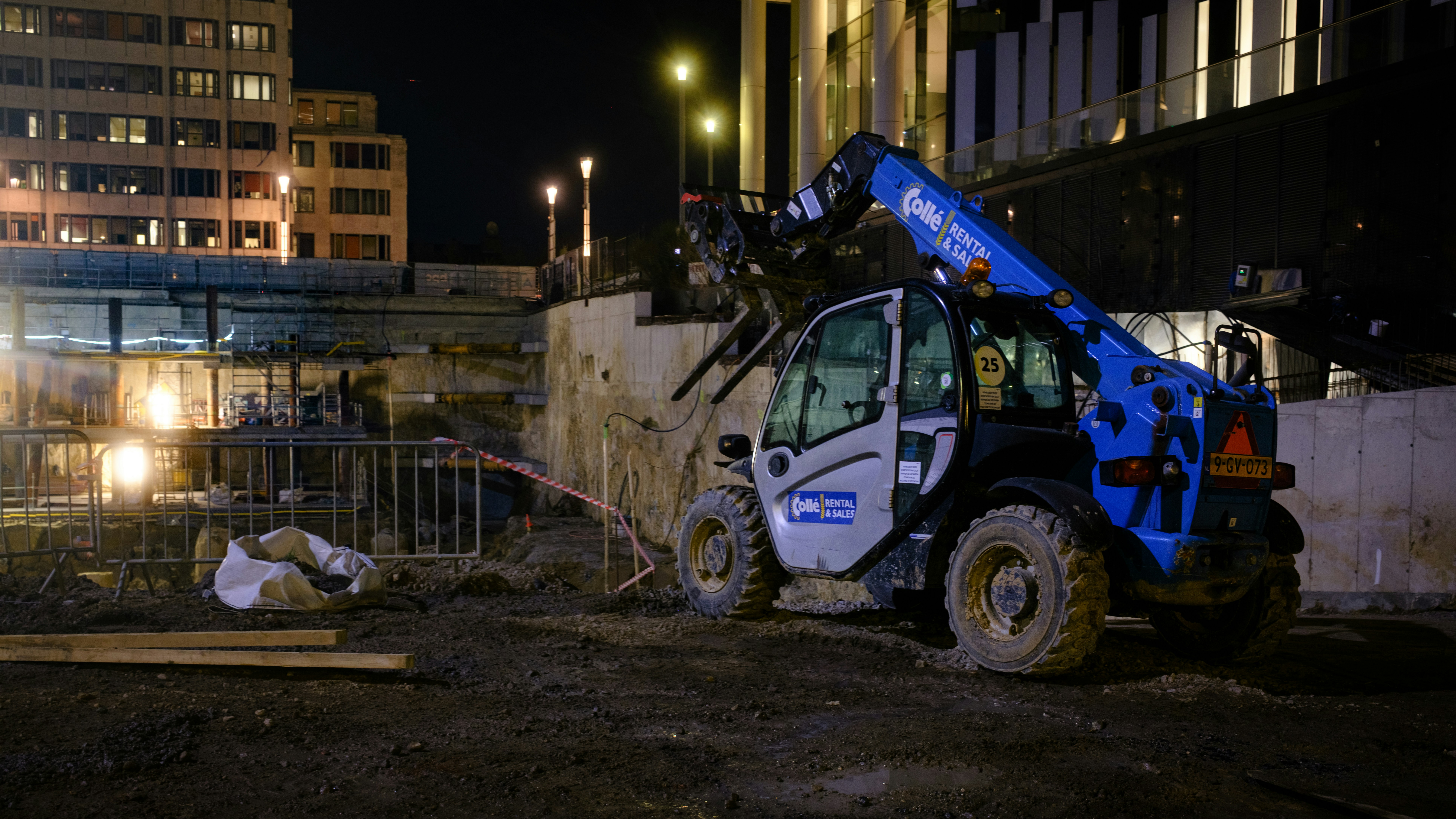 Blue construction vehicle operating at night