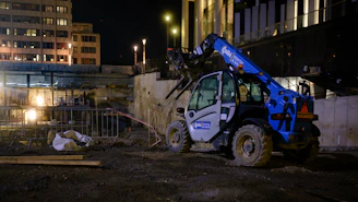 Blue construction vehicle operating at night