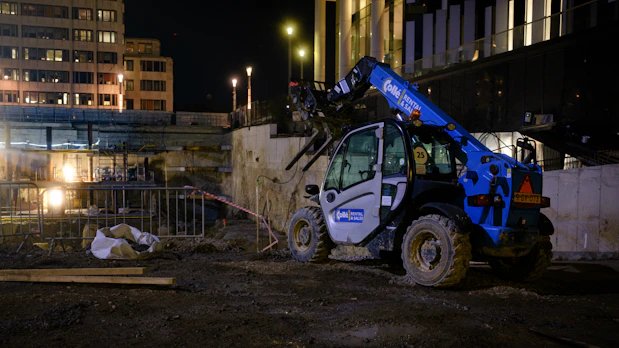 Blue construction vehicle operating at night