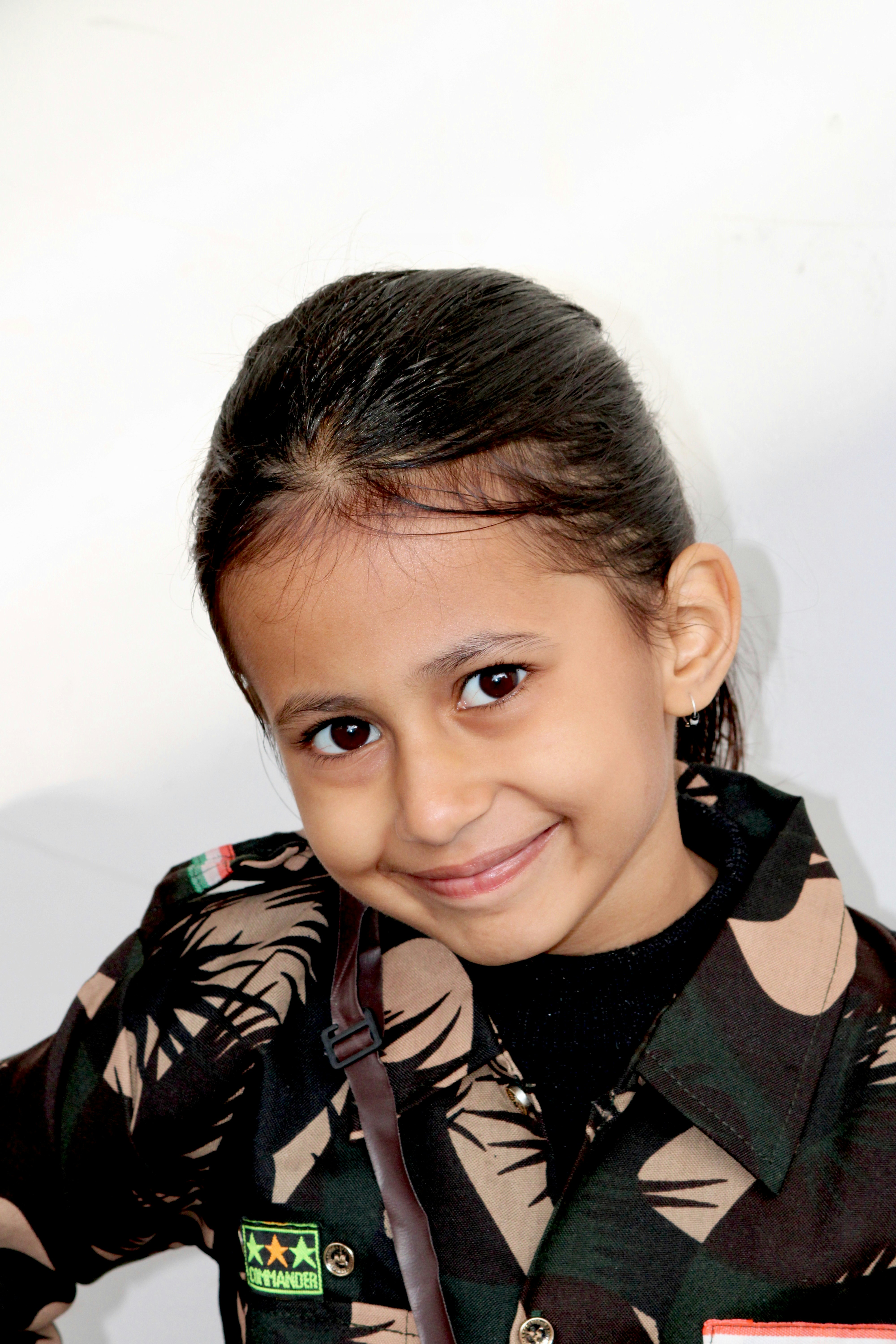 Young girl in camouflage uniform smiles