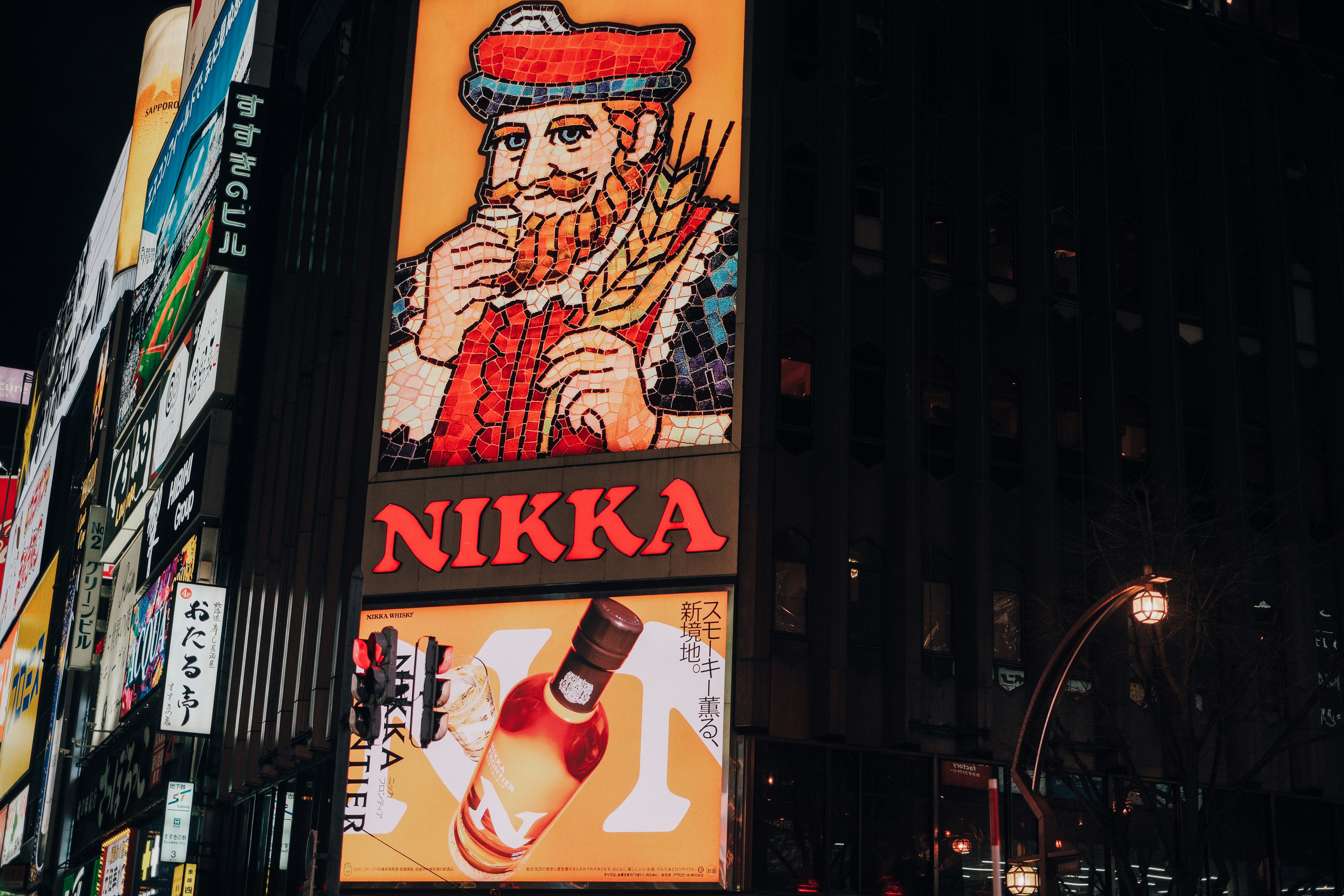 Vintage nikka whisky advertisement on a building at night.