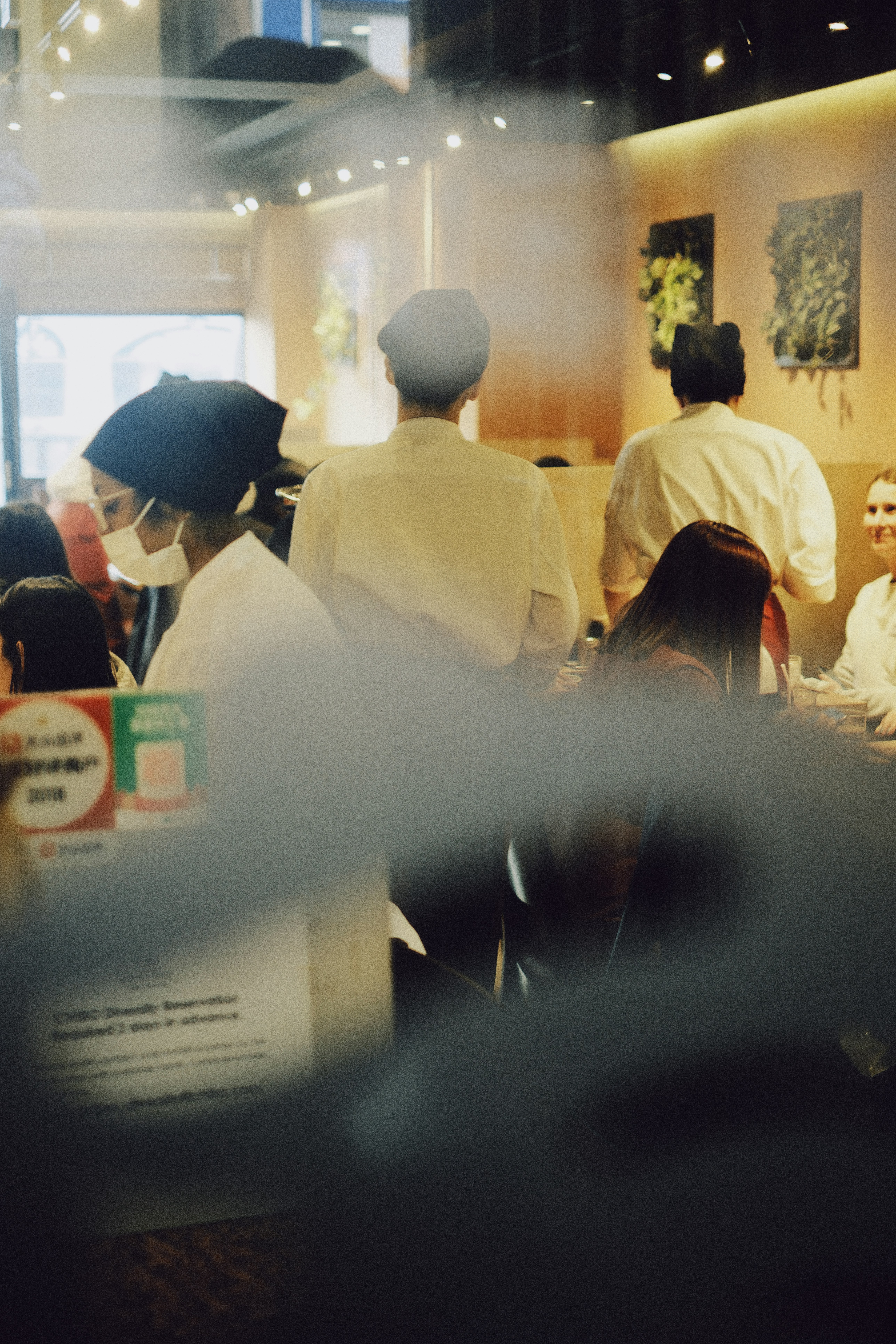 People dining at tables in a brightly lit restaurant.