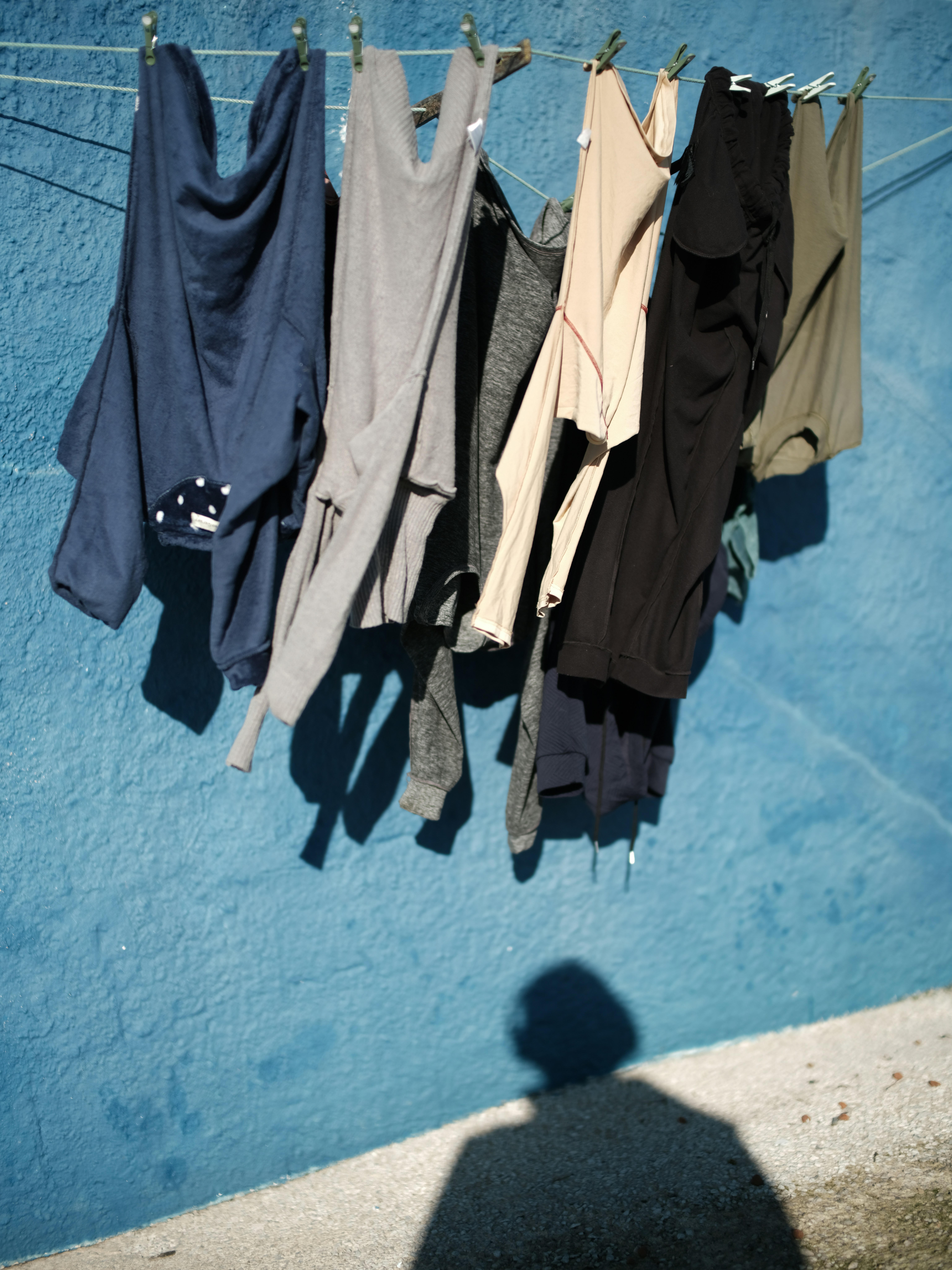Clothes hanging on a line against a blue wall.