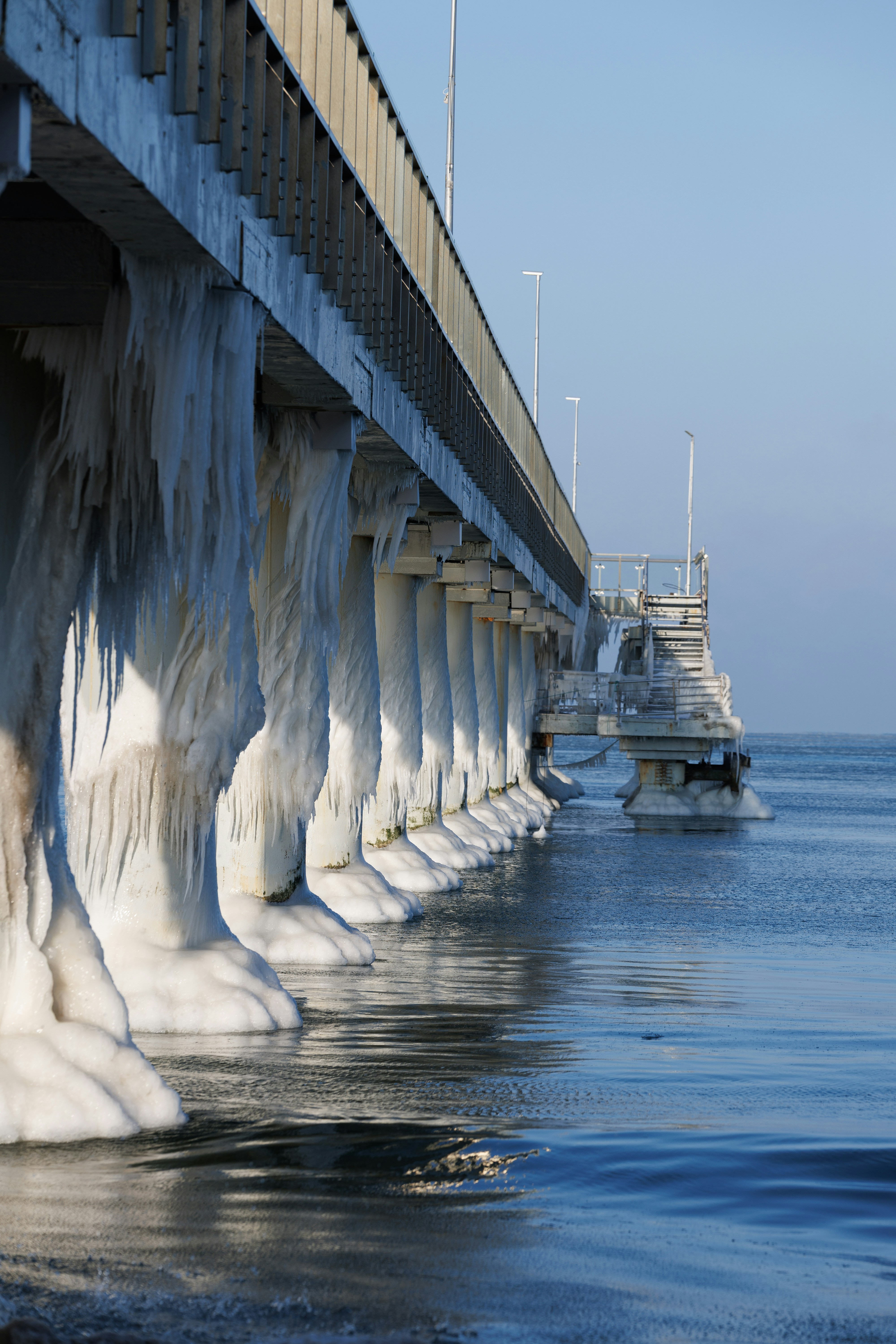 Un pilier de pont recouvert de glace au-dessus de l’eau