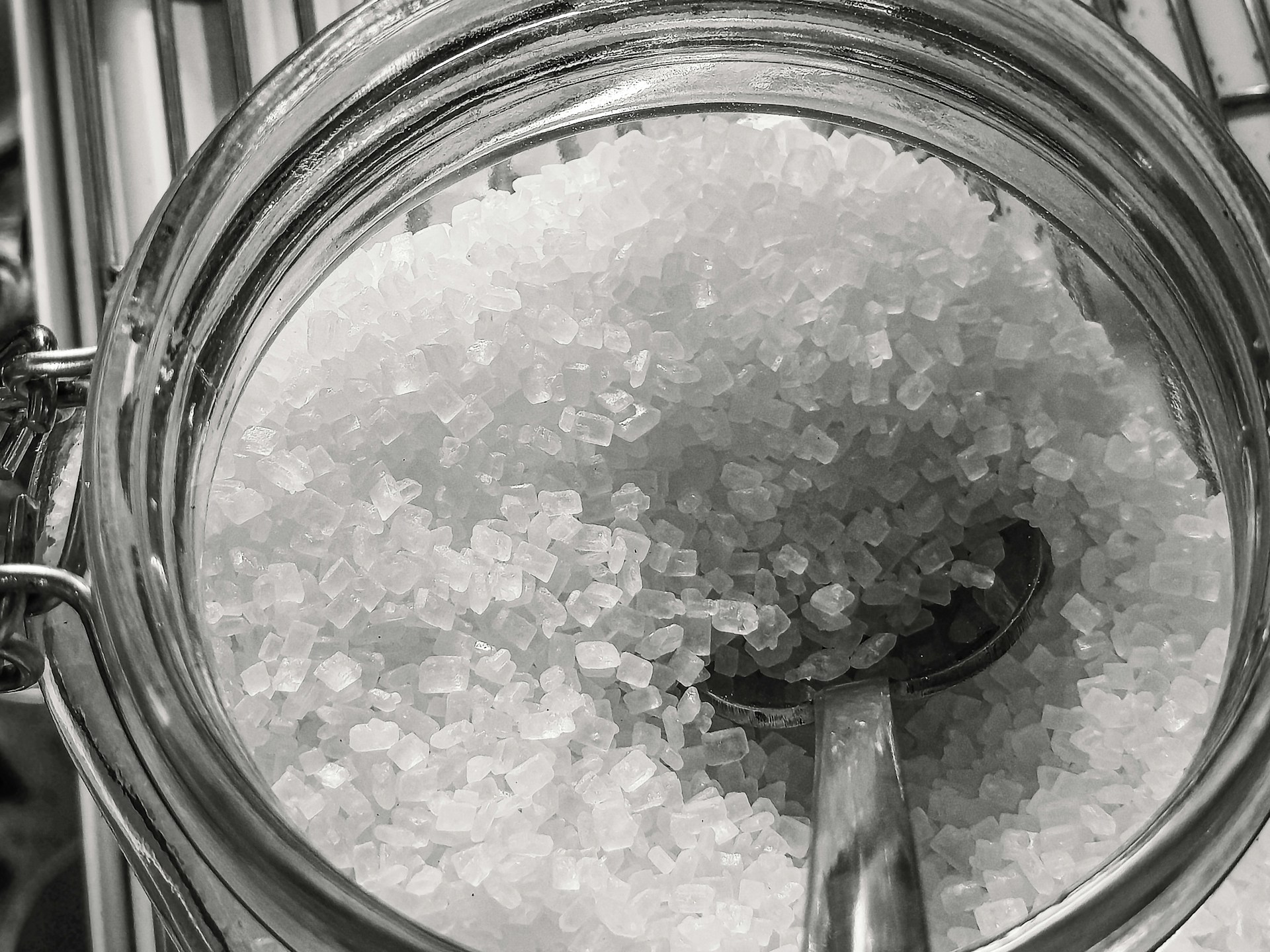 Close-up of coarse salt crystals in a glass jar.