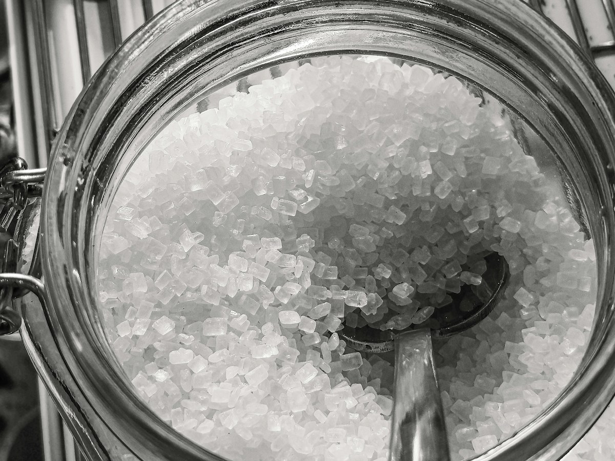 Grobes Salz in einem Glasgefäss mit Löffel, Nahaufnahme