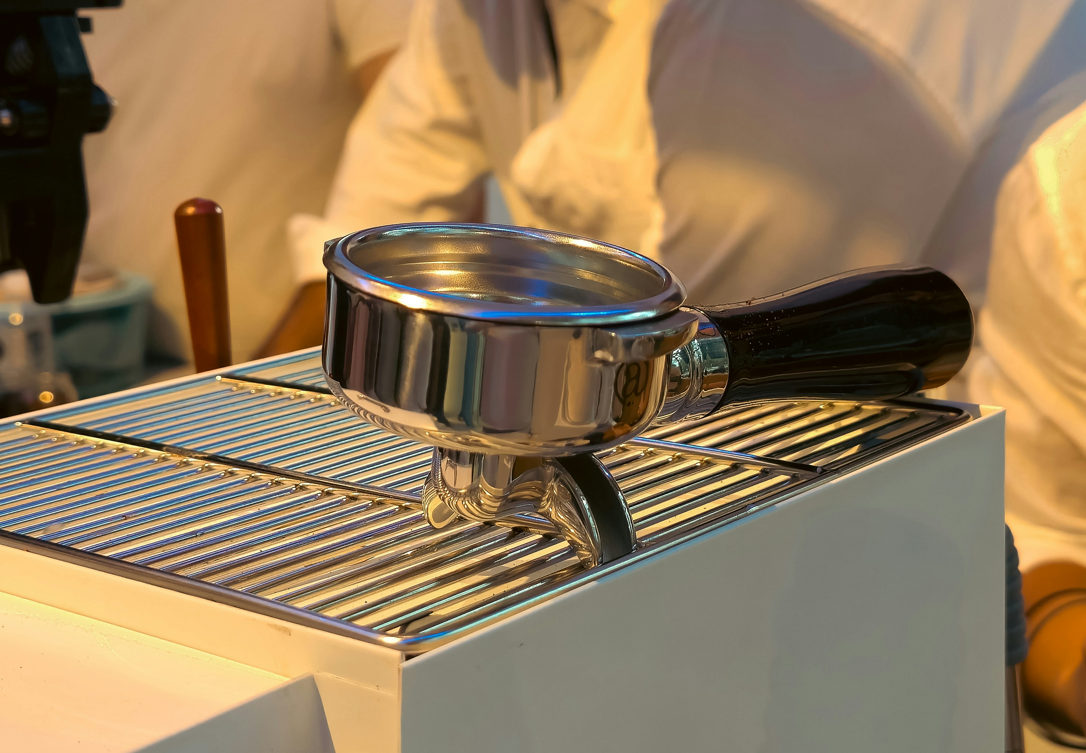 Espresso machine portafilter resting on a drip tray.
