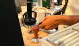 A barista tamping espresso