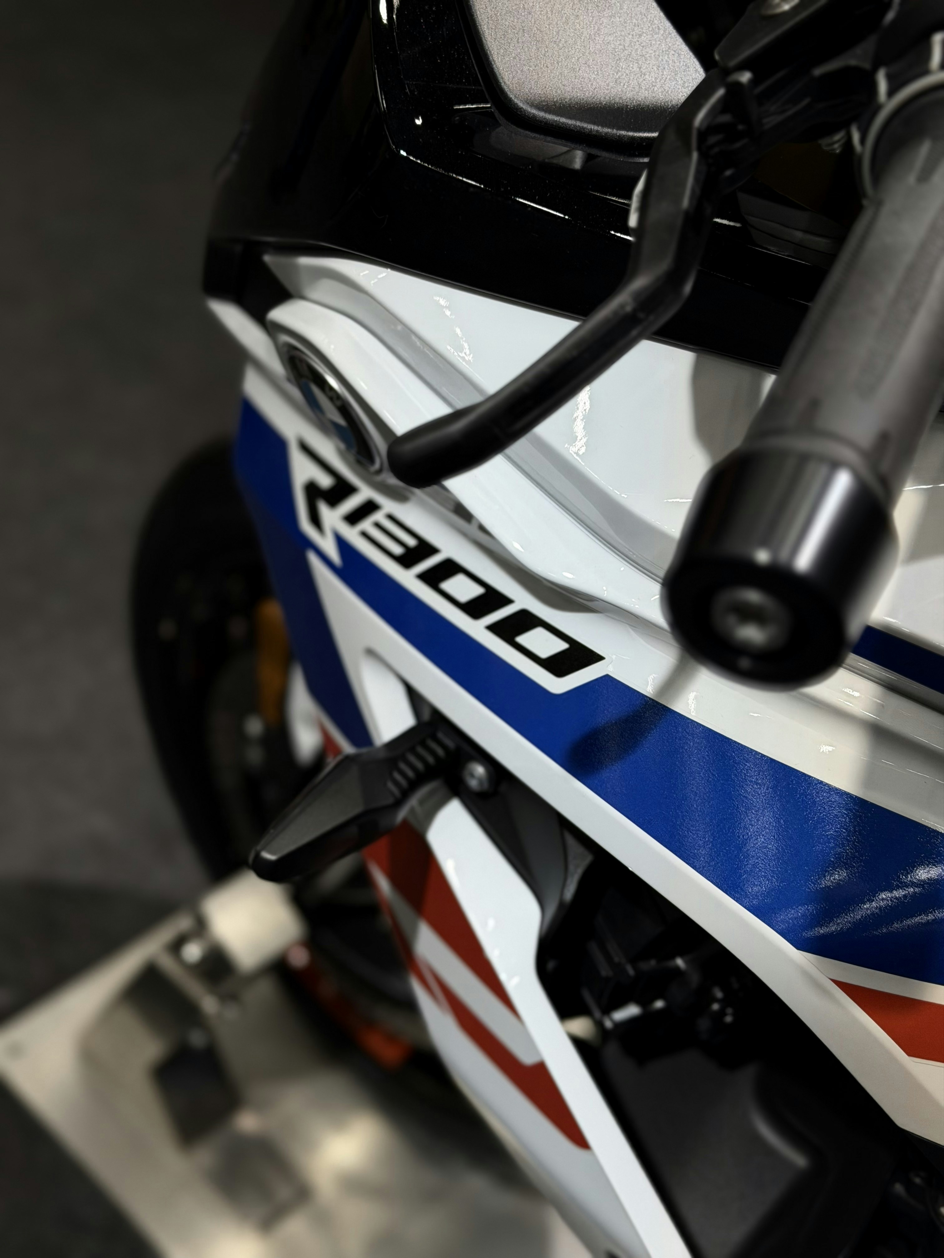 Primer plano de una motocicleta blanca y azul con el logo r1300.
