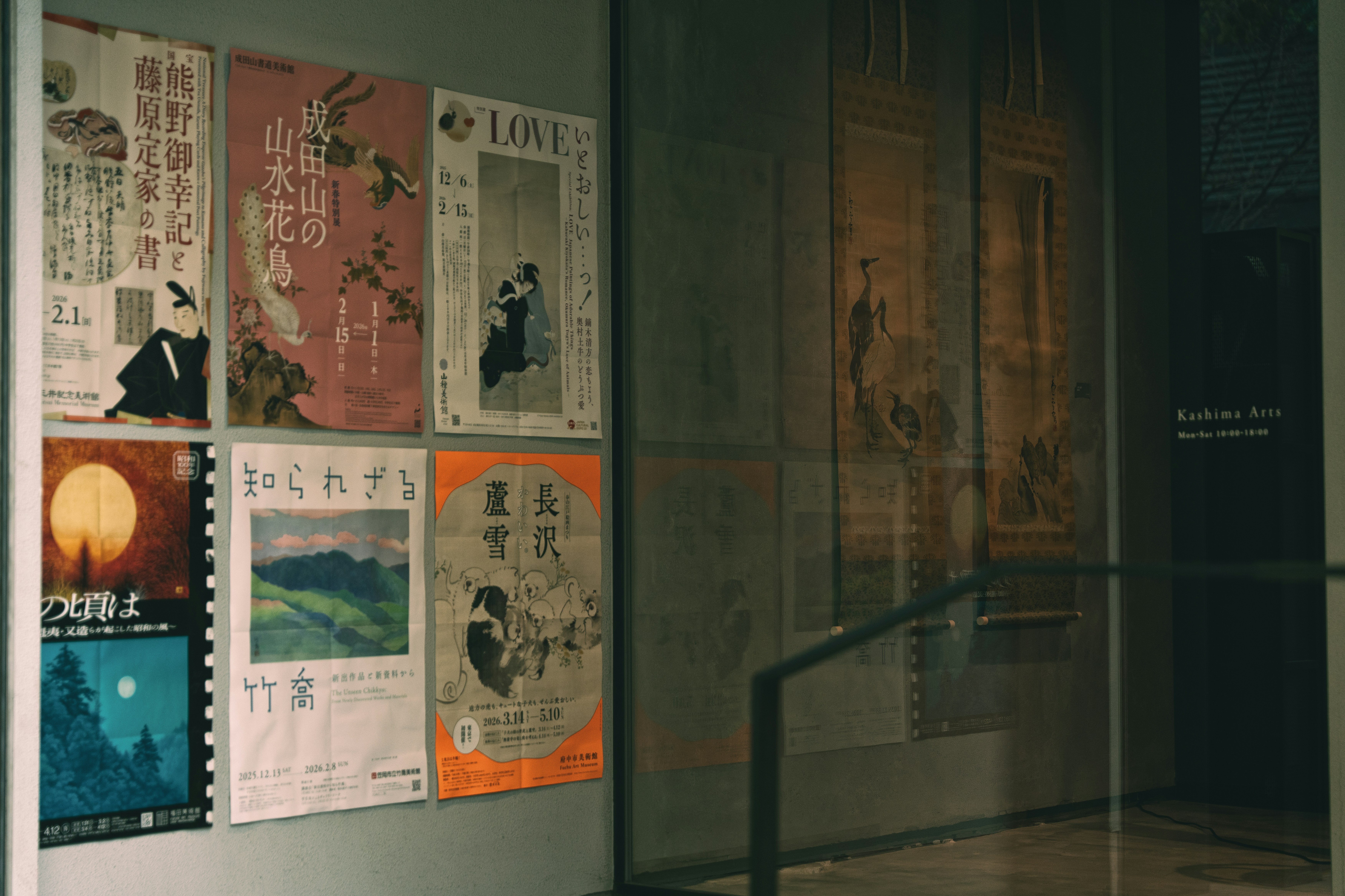 Pôsteres antigos expostos em uma parede de uma galeria.