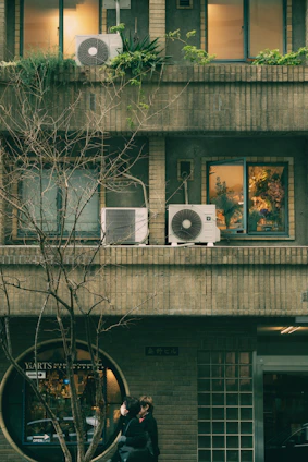 Couple embracing outside a circular window storefront.