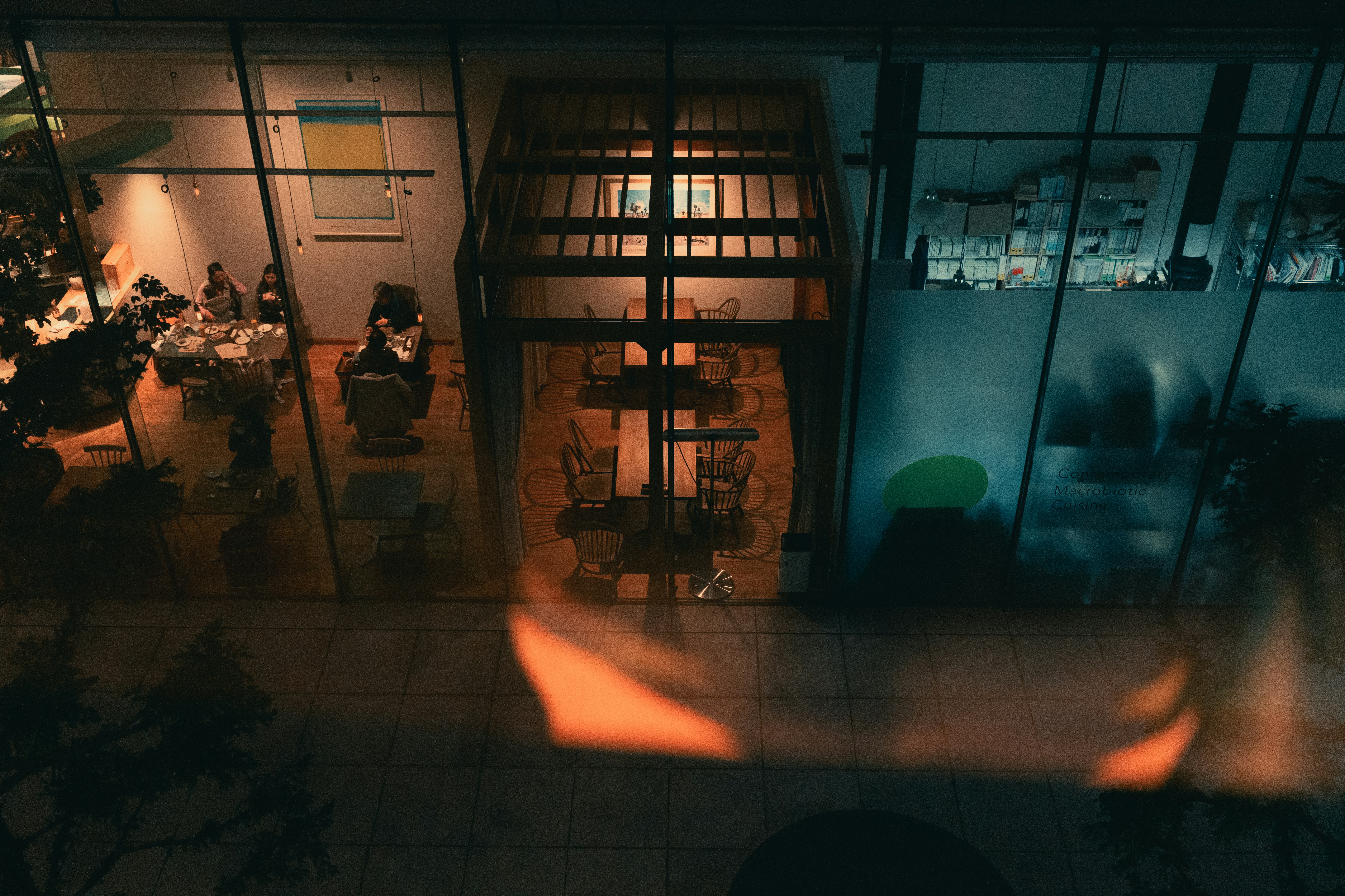 Modern building interior with tables and chairs at night.