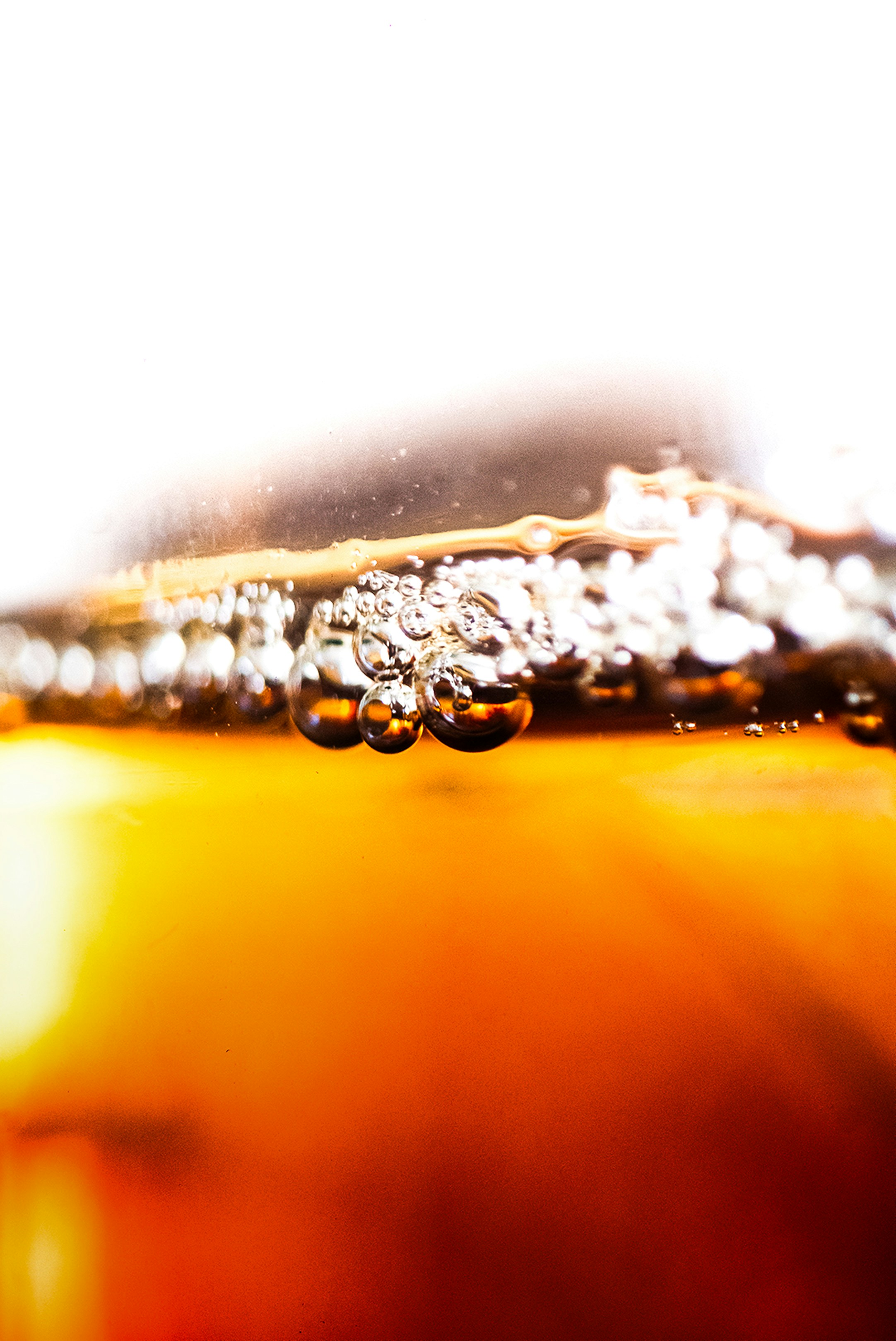 Plan rapproché des bulles se formant dans un liquide ambré