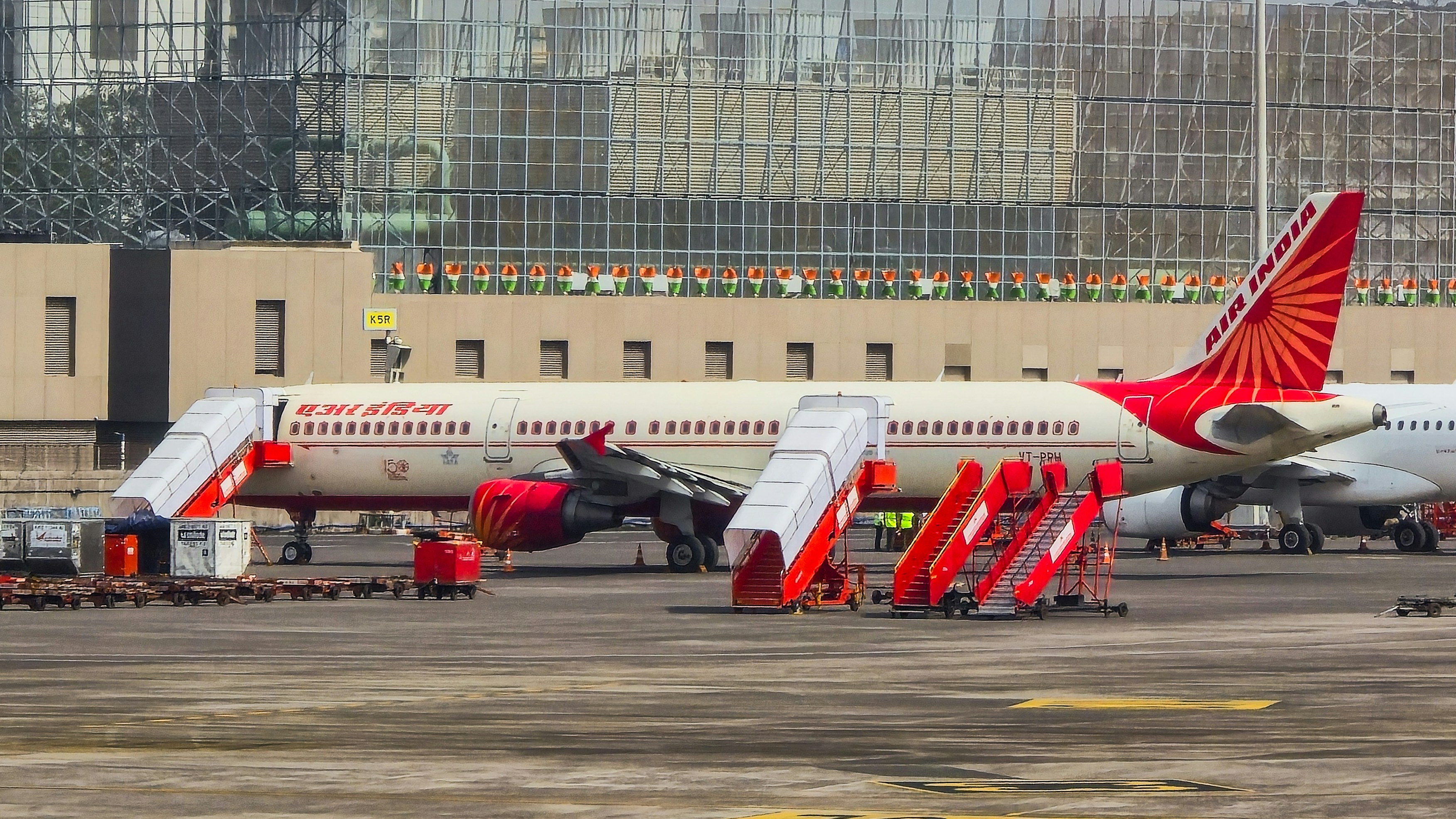 An air india airplane with stairs attached on tarmac.