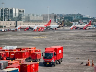 Red trucks and airplanes at an airport tarmac.