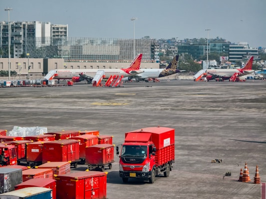 Red trucks and airplanes at an airport tarmac.