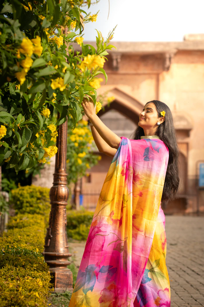 Illustrative stock portrait — Woman in colorful sari reaching for flowers