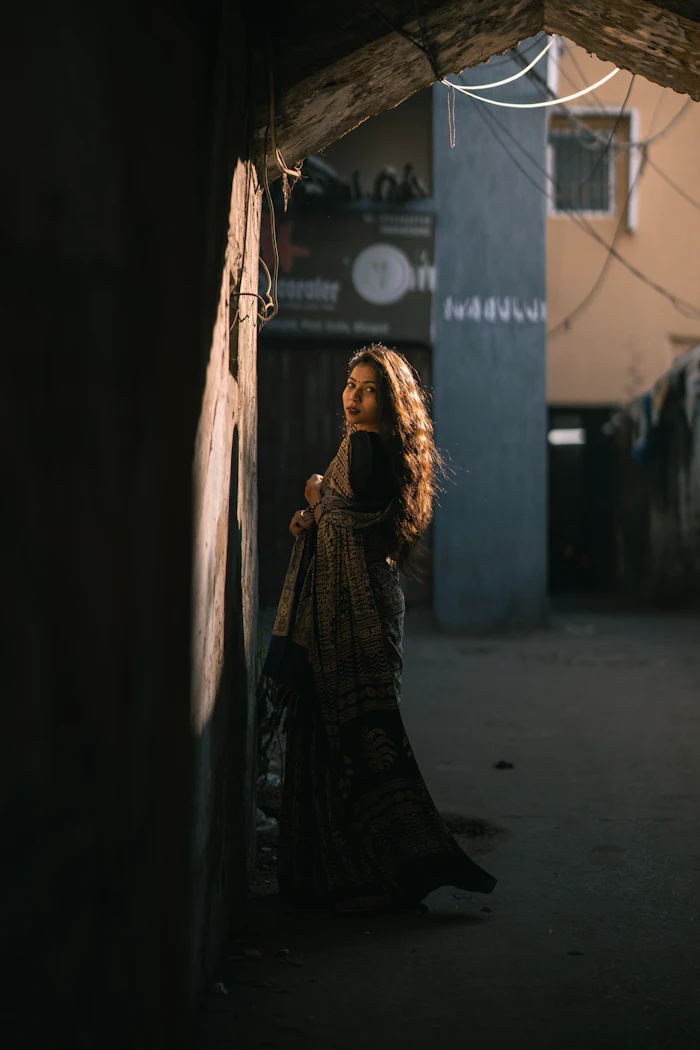 Illustrative stock portrait — Woman in sari in a sunlit alleyway
