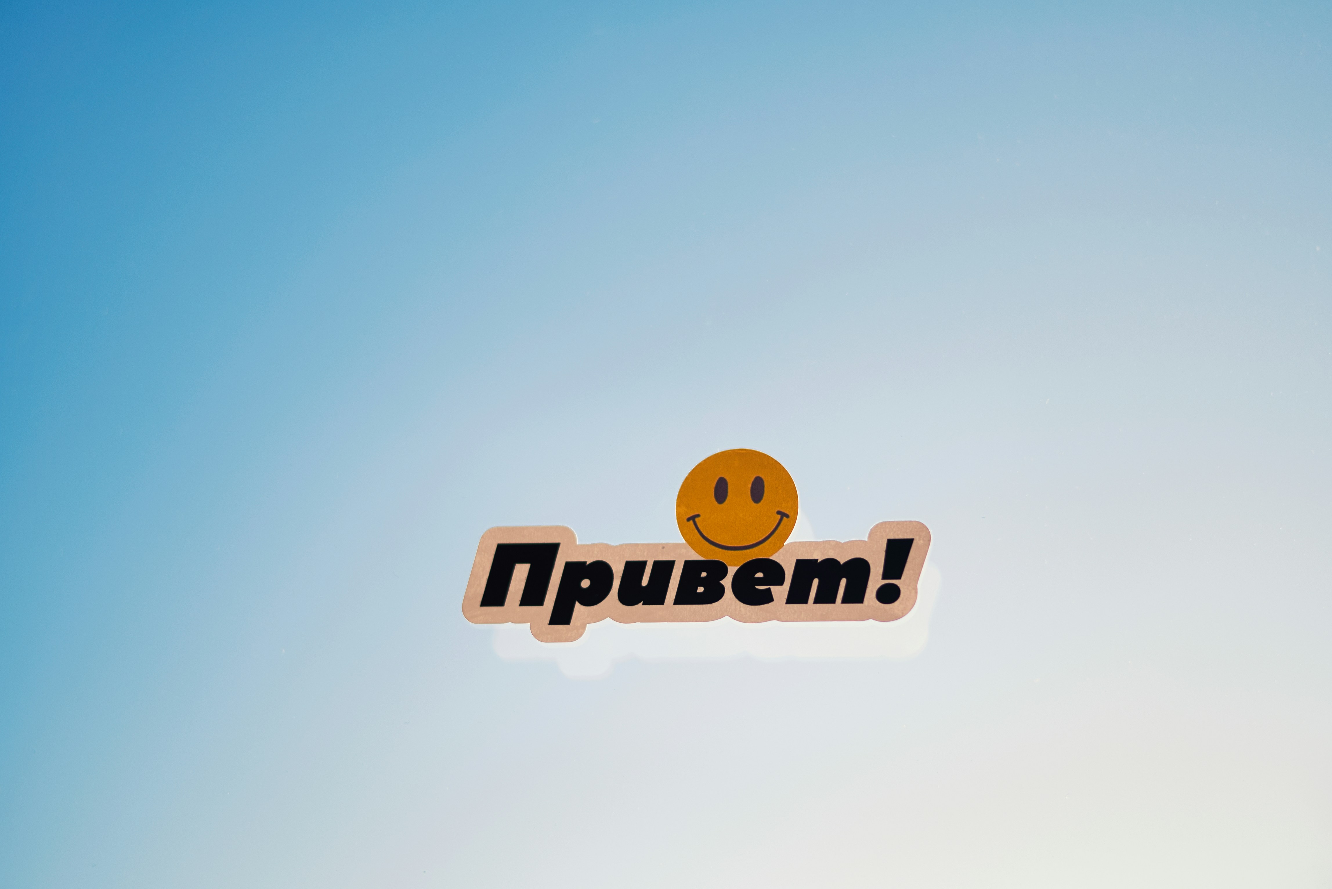 Carita sonriente con la palabra rusa "¡привет!"