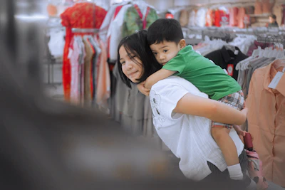 Woman giving a child a piggyback ride in a store.