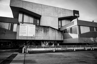 Modern brutalist concrete building with large windows.