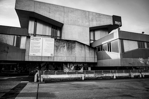 Modern brutalist concrete building with large windows.