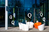 Modern chairs outside a glass building with letter q