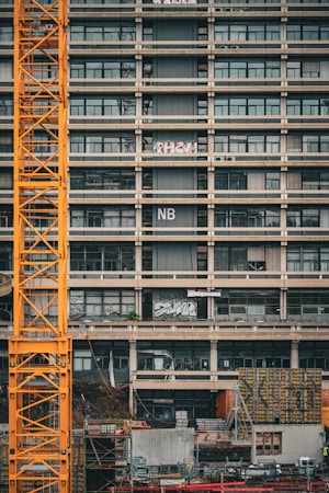 A construction crane working beside a partially finished concrete school building