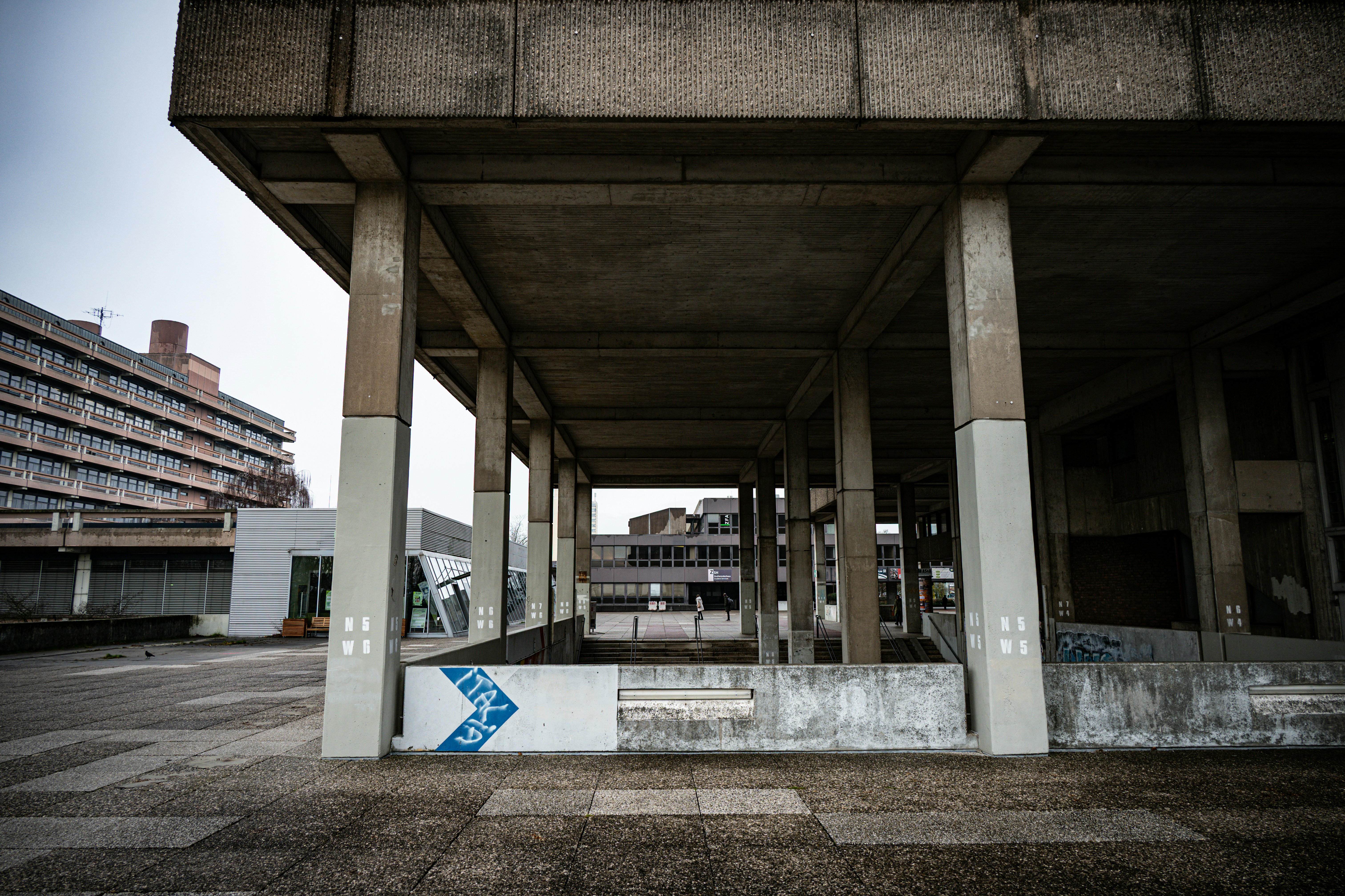 Concrete brutalist architecture with large columns and buildings.