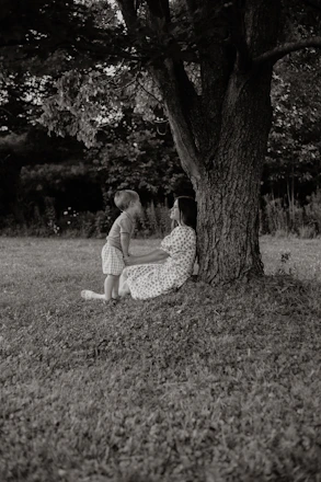 Mother and child resting under a large tree
