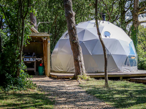 Geodesic dome glamping structure with outdoor kitchen
