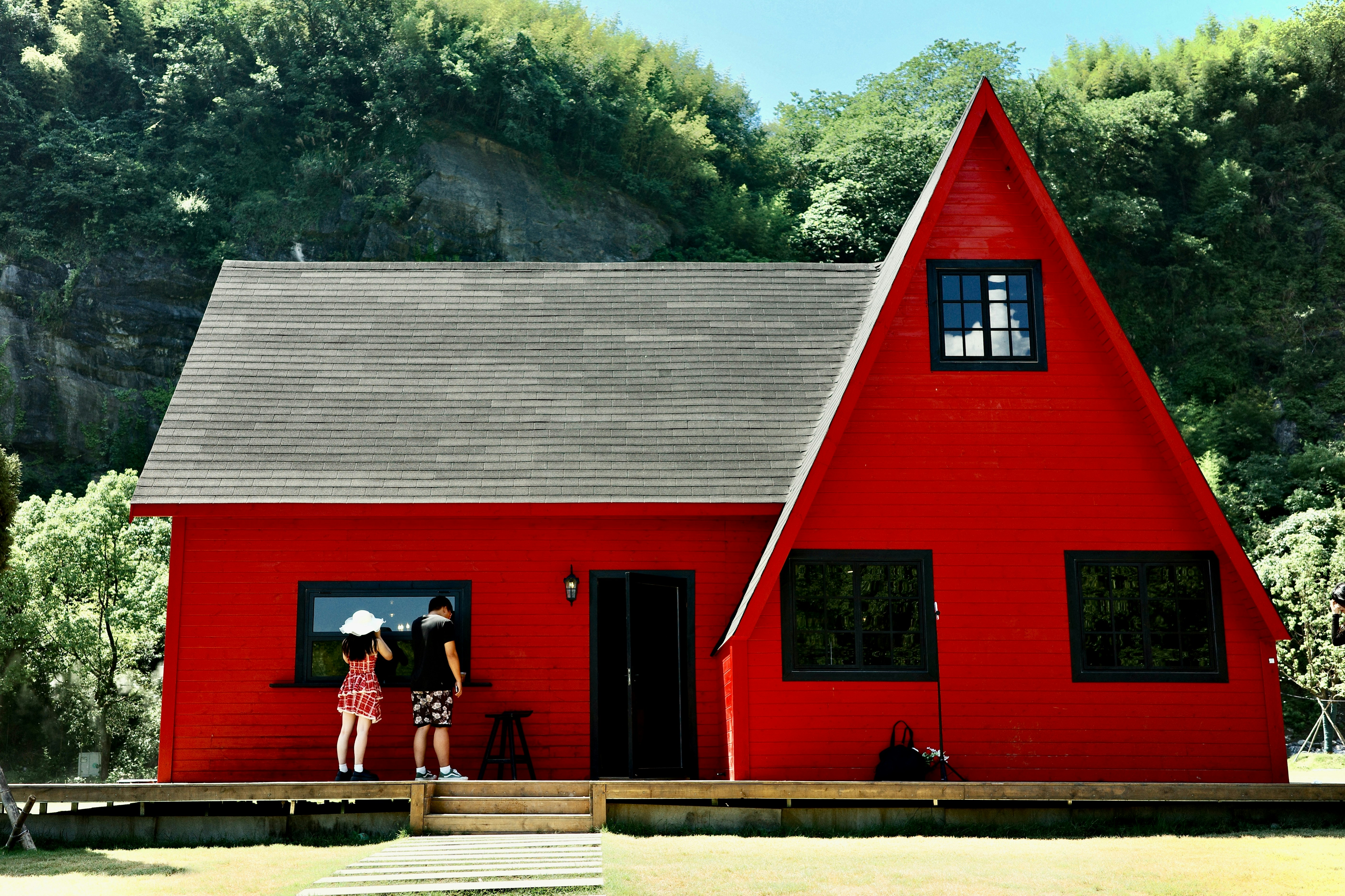 Red a-frame house with people on the porch
