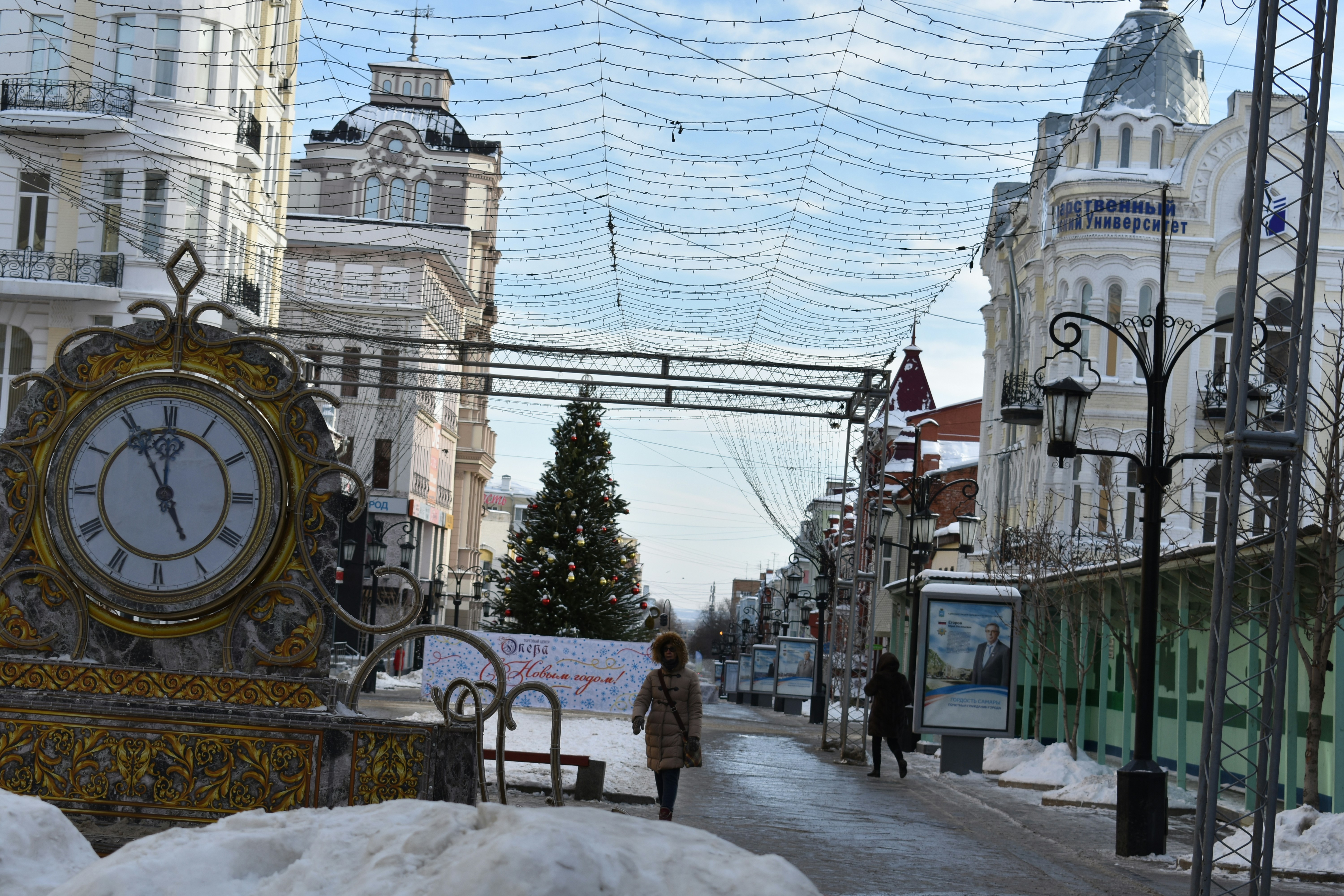 City street decorated for holidays with snow.